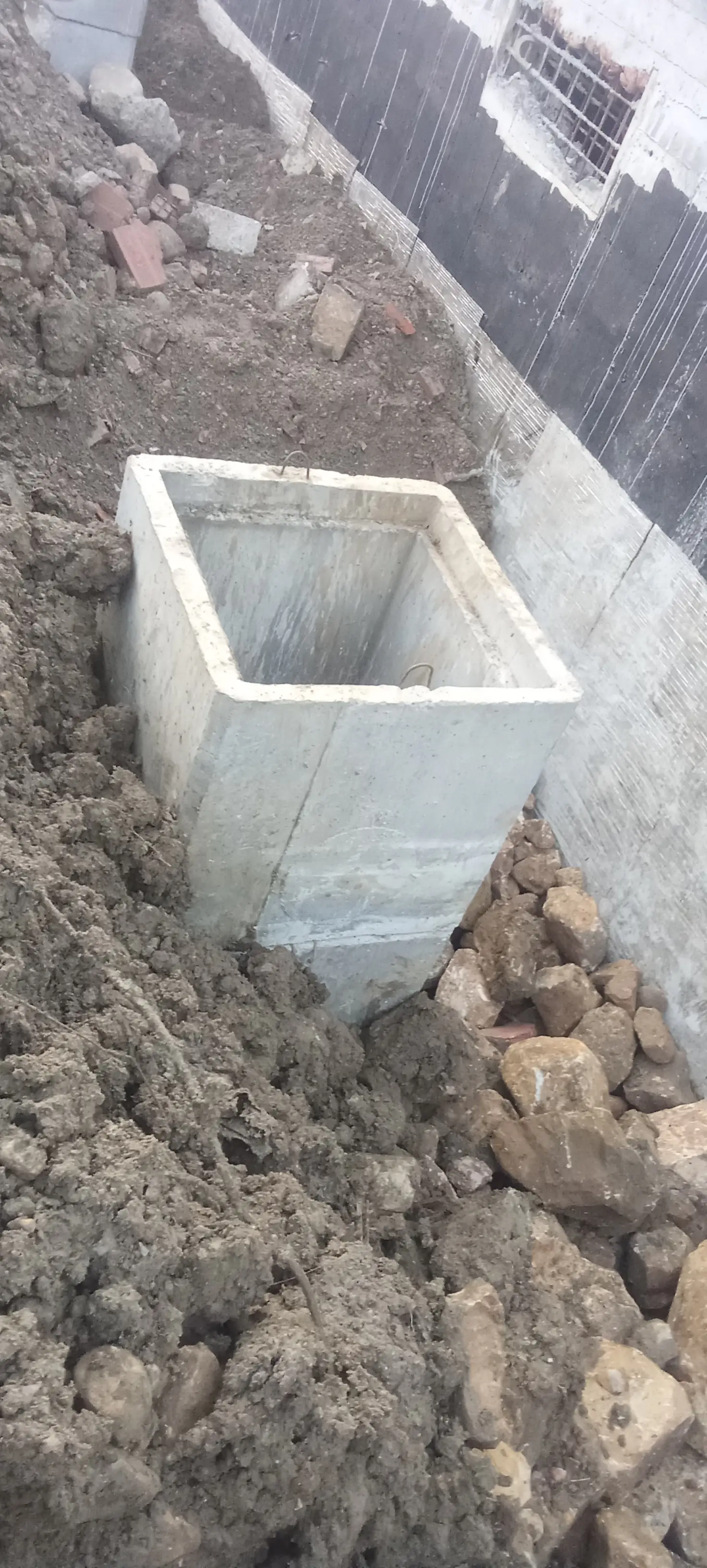 Élément carré en béton en place dans une tranchée